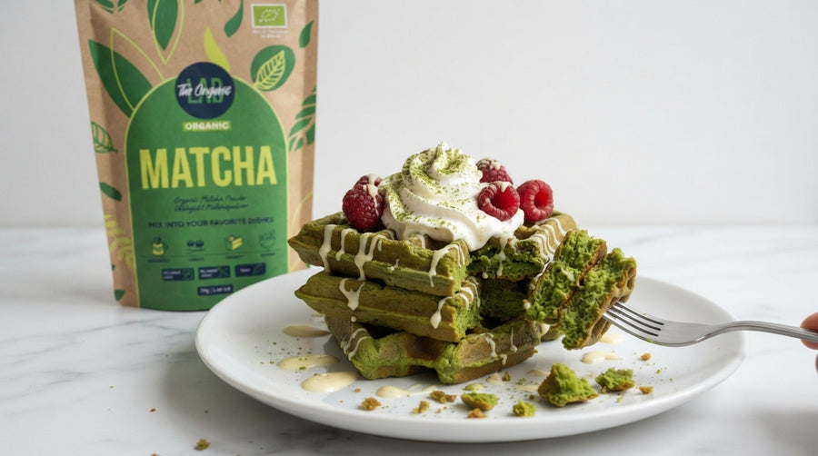 Fluffy matcha waffle with whipped cream and raspberries, made with green tea matcha powder.