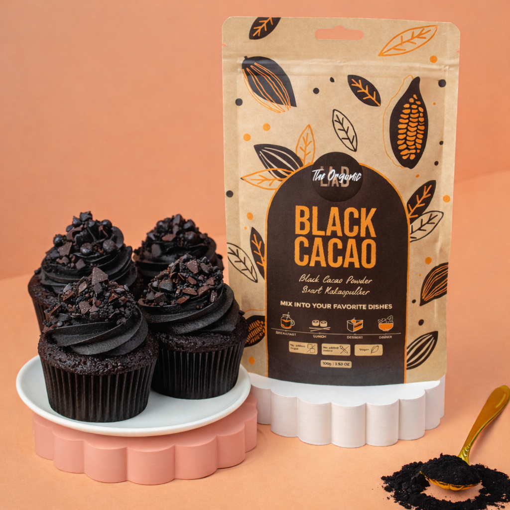 Cupcakes with swirled black cacao frosting on a marble plate beside a Black Cacao Powder pouch