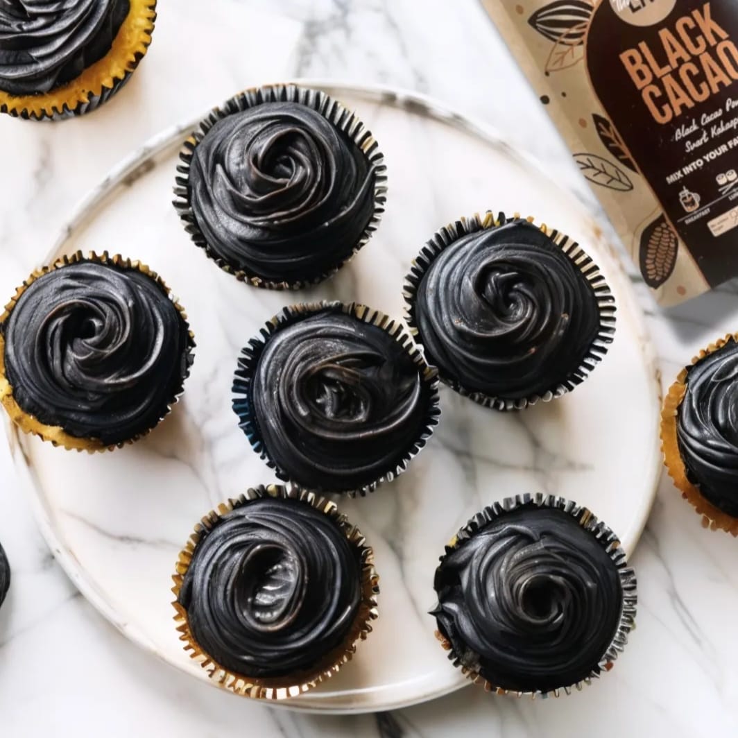 Black cacao cupcakes with dark frosting and chocolate pieces, made with The Organic Lab Black Cacao Powder