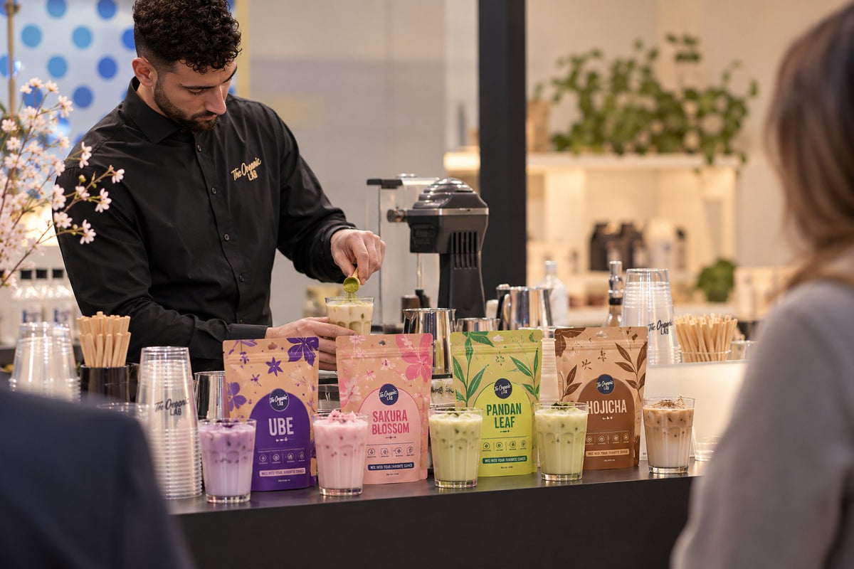Barista preparing colourful superfood drinks at The Organic Labs stand