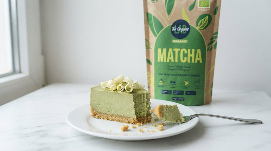 Creamy no-bake matcha cheesecake with a biscuit base, matcha powder and white chocolate curls.